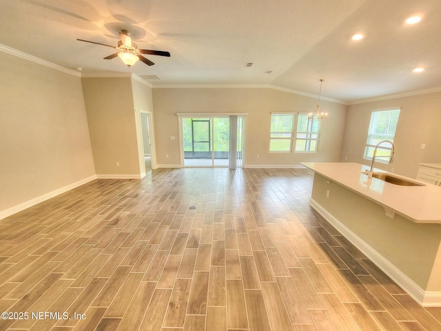 unfurnished living room with plenty of natural light, wood tiled floor, and a sink