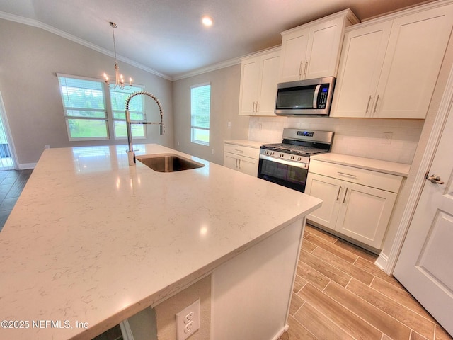 kitchen featuring wood finish floors, stainless steel appliances, lofted ceiling, tasteful backsplash, and a sink