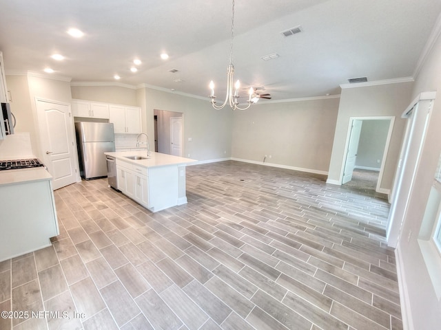 kitchen with visible vents, open floor plan, an inviting chandelier, stainless steel appliances, and a sink