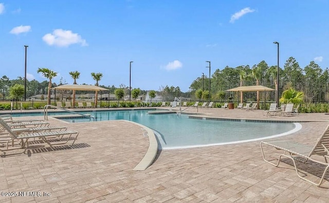 community pool featuring a patio and fence