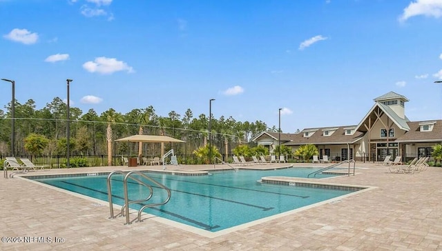 community pool with fence and a patio