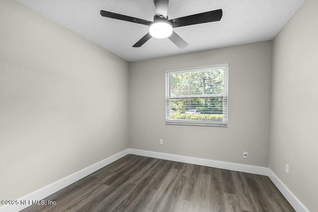 empty room with a ceiling fan, a textured ceiling, baseboards, and dark wood-style flooring