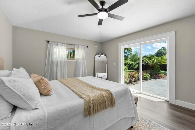 bedroom with access to exterior, multiple windows, baseboards, and wood finished floors