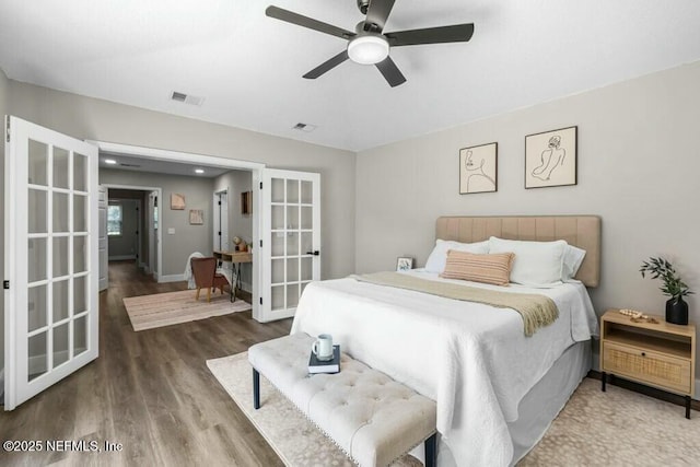 bedroom with french doors, visible vents, ceiling fan, and wood finished floors