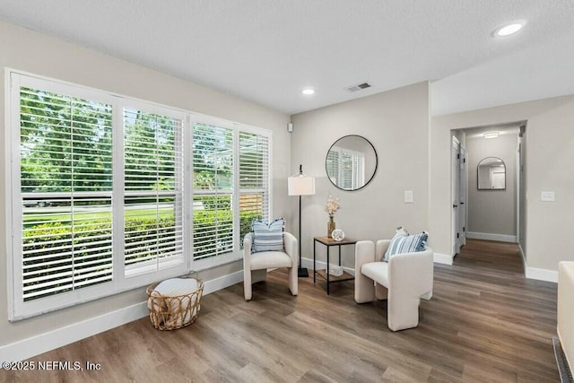 living area featuring recessed lighting, wood finished floors, visible vents, and baseboards