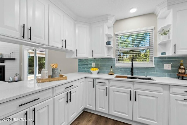 kitchen featuring open shelves, a sink, light countertops, and white cabinets