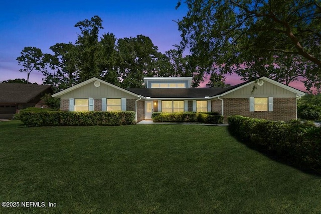 ranch-style home with brick siding and a front yard