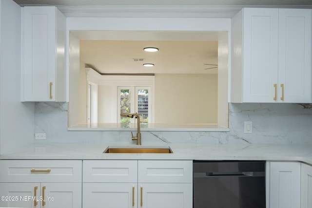 kitchen with dishwasher, backsplash, a sink, and white cabinets