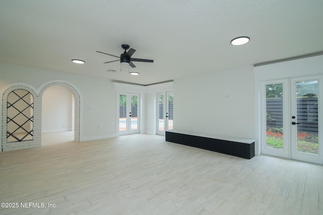 empty room featuring french doors, plenty of natural light, and wood finished floors