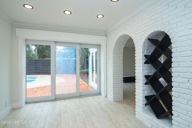 interior space with recessed lighting, crown molding, brick wall, and wood finished floors