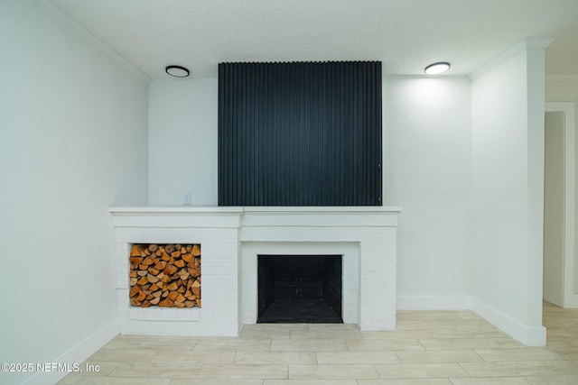 interior details featuring baseboards, wood finished floors, a textured ceiling, crown molding, and a fireplace