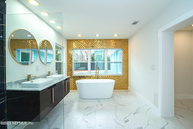 bathroom with a sink, visible vents, marble finish floor, a soaking tub, and double vanity