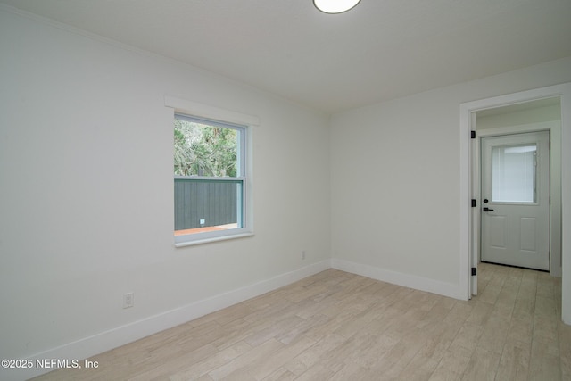 empty room with light wood finished floors and baseboards