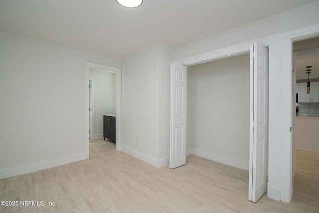 unfurnished bedroom featuring light wood-type flooring and baseboards