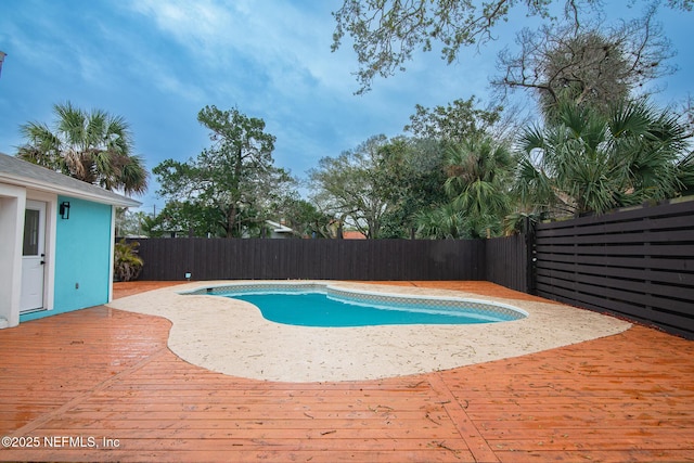 view of pool with a fenced in pool, a fenced backyard, and a wooden deck