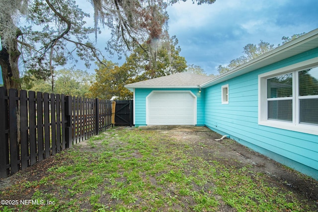 view of yard featuring a garage and a fenced backyard