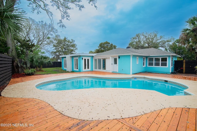 pool with french doors and a fenced backyard