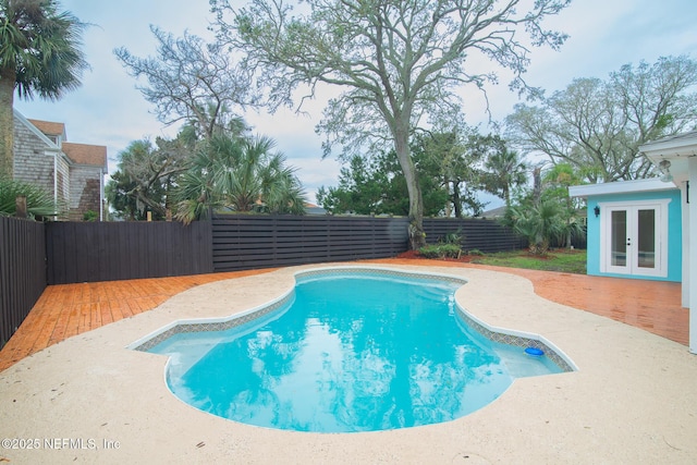 view of swimming pool featuring a fenced in pool, french doors, a fenced backyard, and a patio