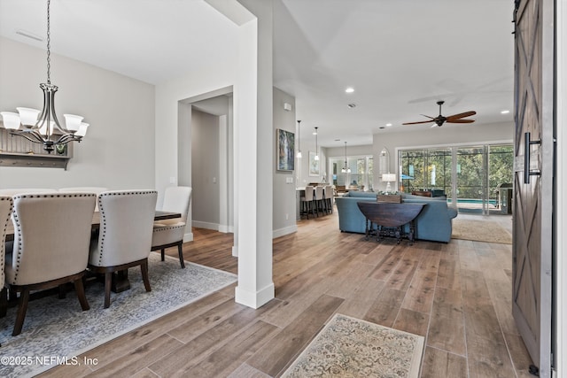 dining space with ceiling fan with notable chandelier, recessed lighting, baseboards, and wood finished floors