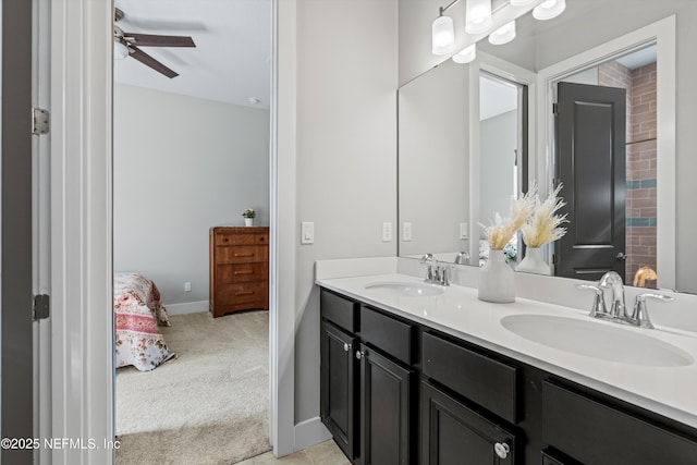 bathroom featuring ceiling fan, double vanity, a sink, and baseboards