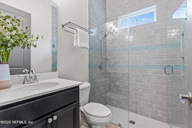 bathroom featuring toilet, a stall shower, and vanity