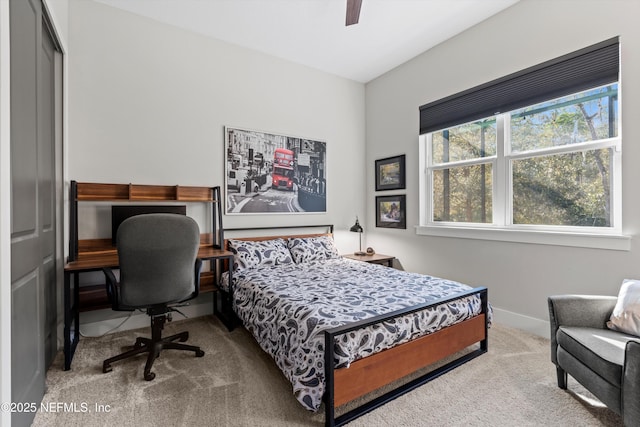 carpeted bedroom with ceiling fan and baseboards