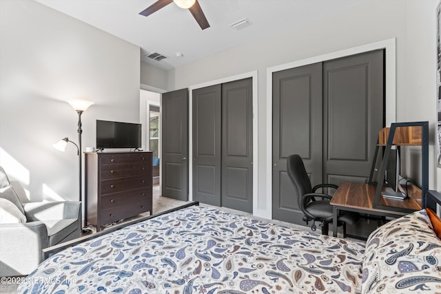 bedroom with ceiling fan, visible vents, and multiple closets