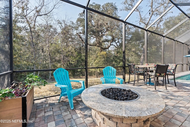 view of patio featuring a fire pit and glass enclosure