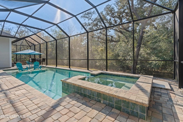 view of pool with a lanai, a patio area, and a pool with connected hot tub