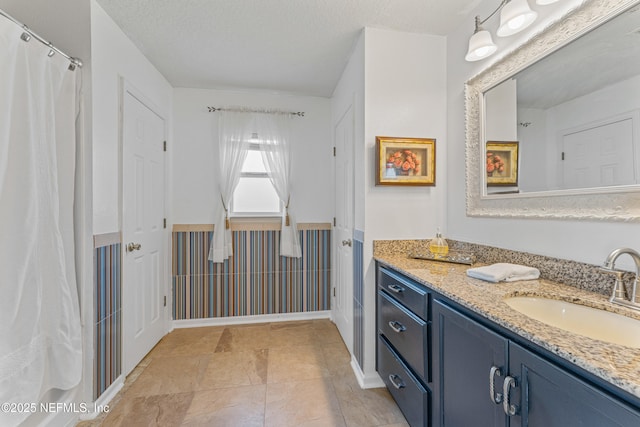 full bathroom with a textured ceiling and vanity