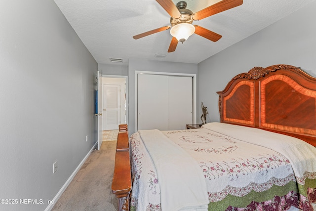 carpeted bedroom with a closet, visible vents, ceiling fan, a textured ceiling, and baseboards