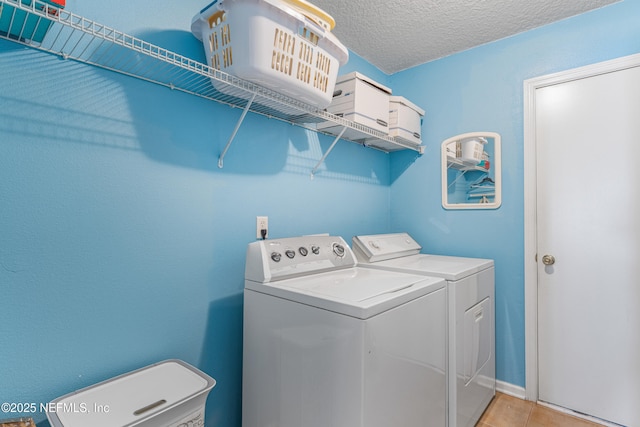 laundry area featuring washing machine and dryer, laundry area, and a textured ceiling