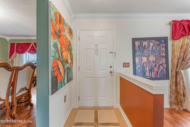 entrance foyer featuring crown molding, a textured ceiling, baseboards, and wood finished floors