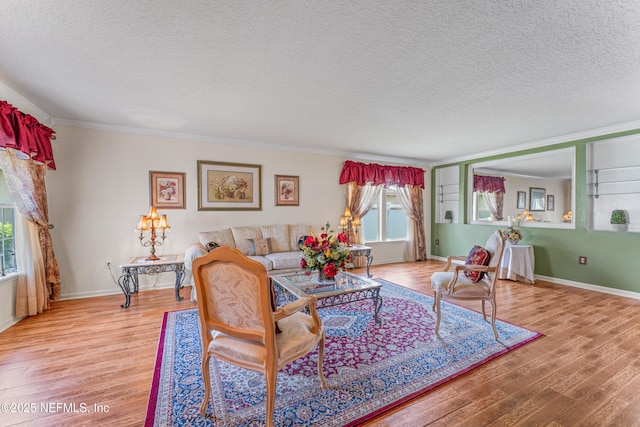 living room with a textured ceiling, ornamental molding, and wood finished floors