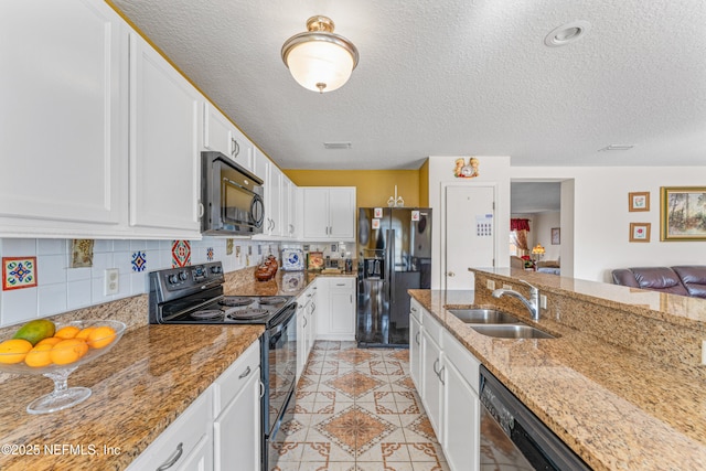 kitchen featuring light tile patterned floors, tasteful backsplash, white cabinets, a sink, and black appliances