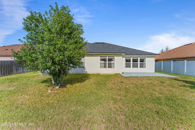 back of property featuring stucco siding, a lawn, and a patio