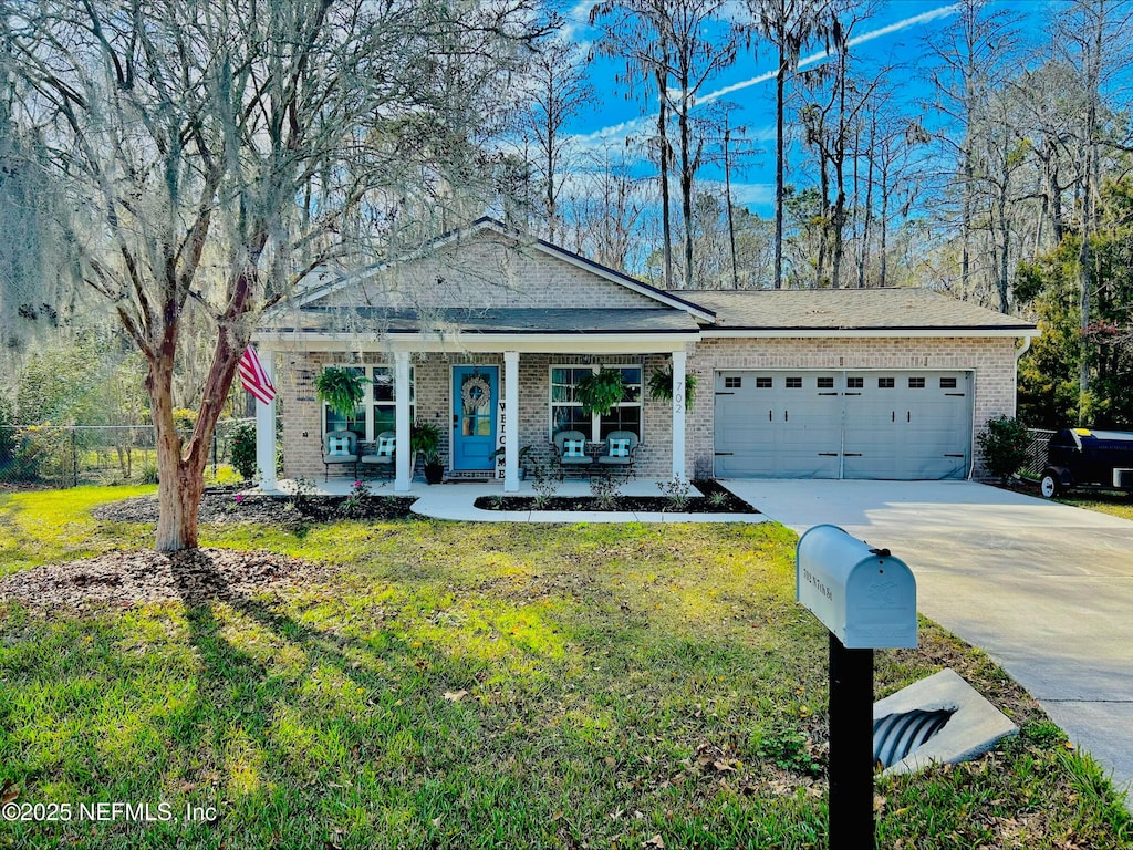 view of front of property featuring a porch, a garage, brick siding, concrete driveway, and a front lawn