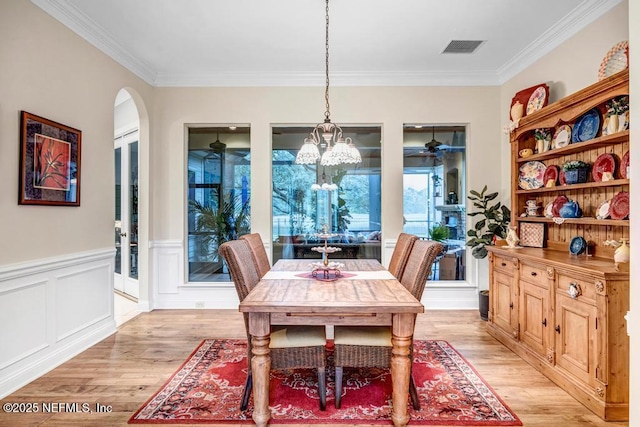 dining area with ornamental molding, light wood-type flooring, and visible vents