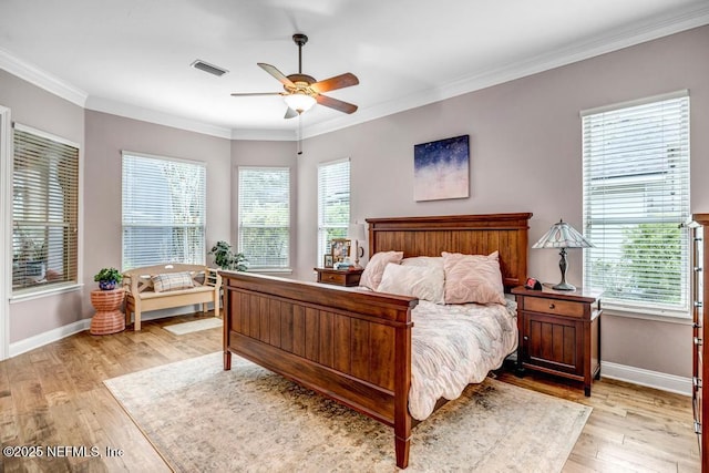 bedroom featuring ornamental molding, light wood-type flooring, visible vents, and baseboards