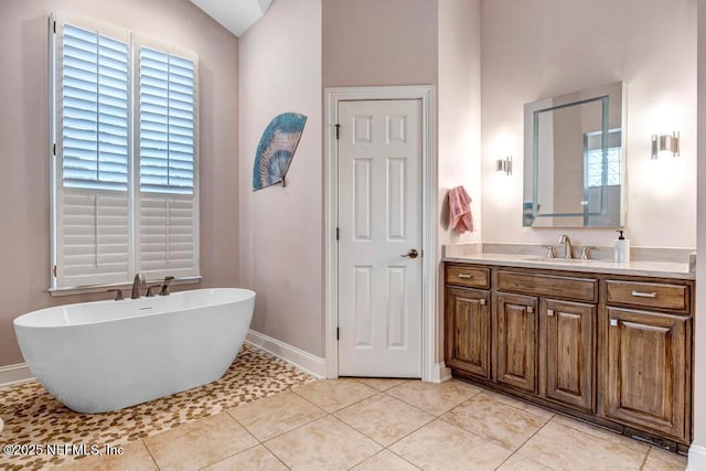 full bath with a soaking tub, tile patterned flooring, a wealth of natural light, and vanity