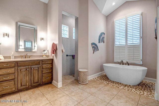 full bath with lofted ceiling, a walk in shower, a freestanding tub, tile patterned flooring, and vanity