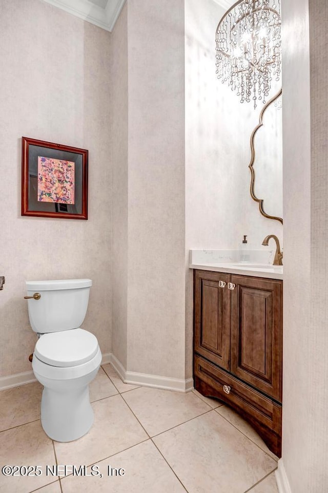 half bath with baseboards, toilet, ornamental molding, tile patterned flooring, and vanity