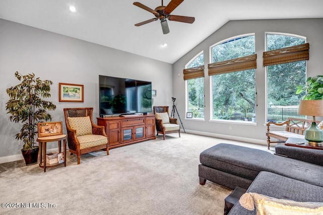 carpeted living area with a ceiling fan, high vaulted ceiling, and baseboards