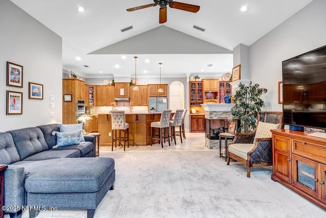 living room with arched walkways, light carpet, visible vents, and recessed lighting