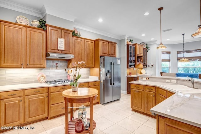 kitchen with stainless steel appliances, backsplash, light countertops, and under cabinet range hood