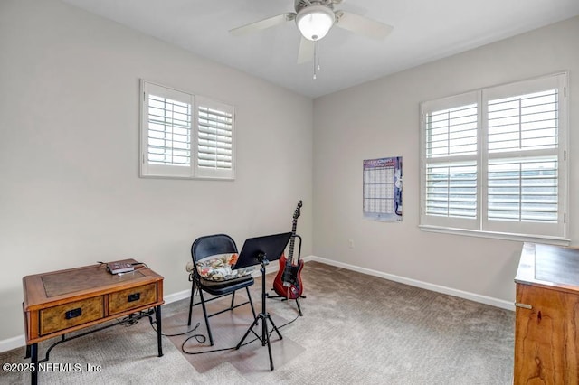 carpeted office with baseboards and a ceiling fan