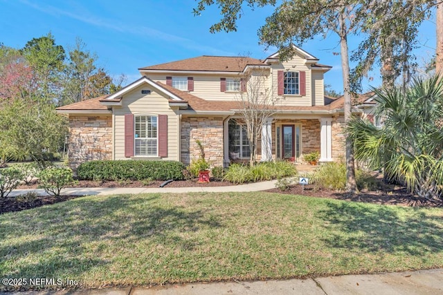 traditional-style house with stone siding and a front yard