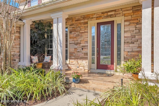 property entrance with stone siding, a porch, and brick siding