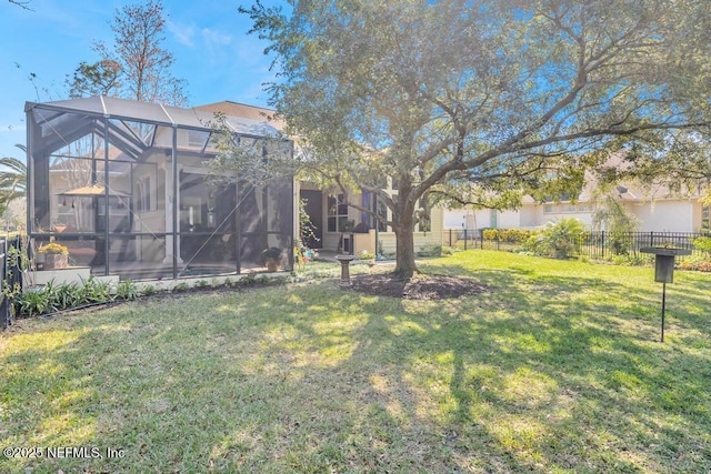 view of yard with glass enclosure and fence