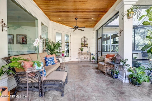 sunroom featuring a ceiling fan and wood ceiling